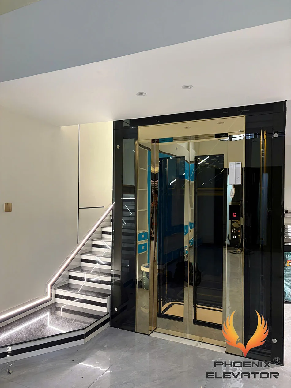 Cabin kính quan sát khung inox gương vàng, kính màu trà đặt cạnh cầu thang nhà phố