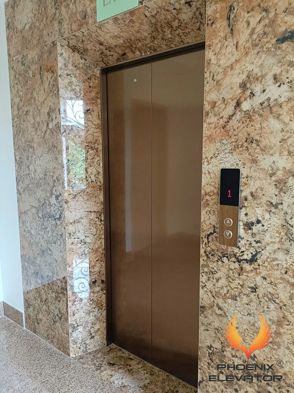 Ốp đá hoa cương vàng quanh cửa tầng thang máy khung inox gương đồng, tông ấm champagne