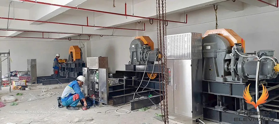Phòng máy thang máy với hai máy kéo đặt trên hệ đà thép và tủ điện inox